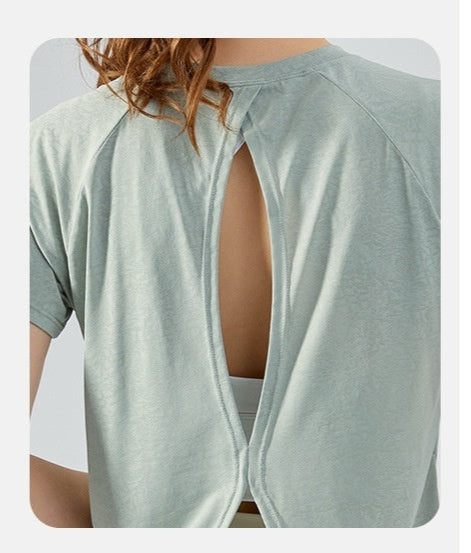 Light green top with back cutout and symmetrical slits on a white background