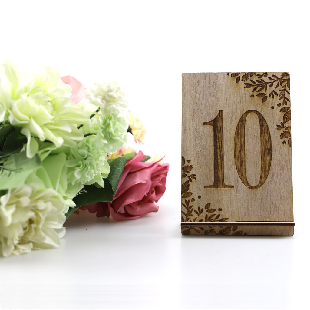 Wooden table number '10' with floral decorations on a white background