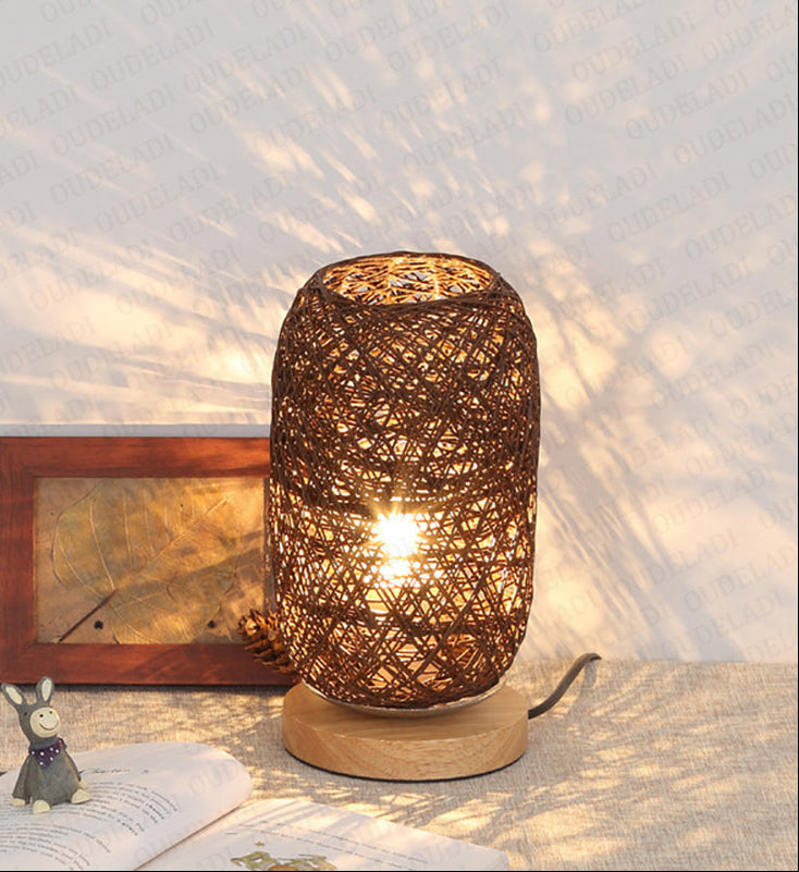 Woven rattan table lamp on a surface with a soft light background