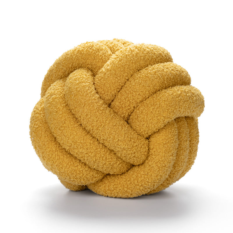 Yellow knotted ball toy on a white background