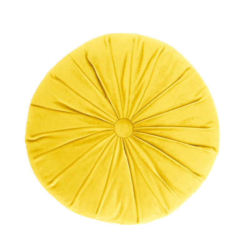 Yellow round pillow with pleated texture on a white background