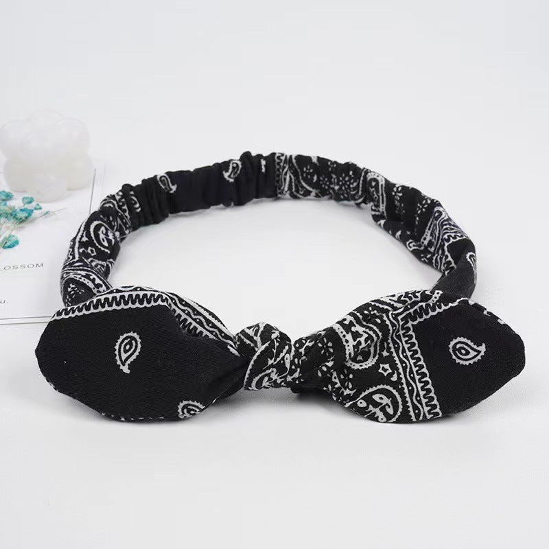 Black and white patterned headband on a light gray background