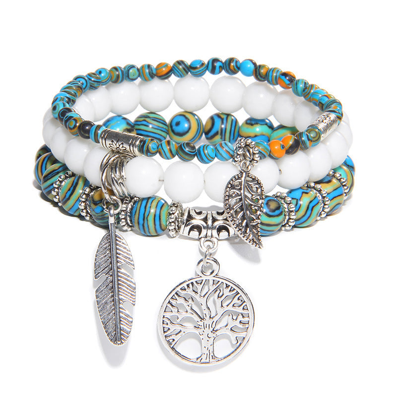 Stack of colorful beaded bracelets with charms on a white background