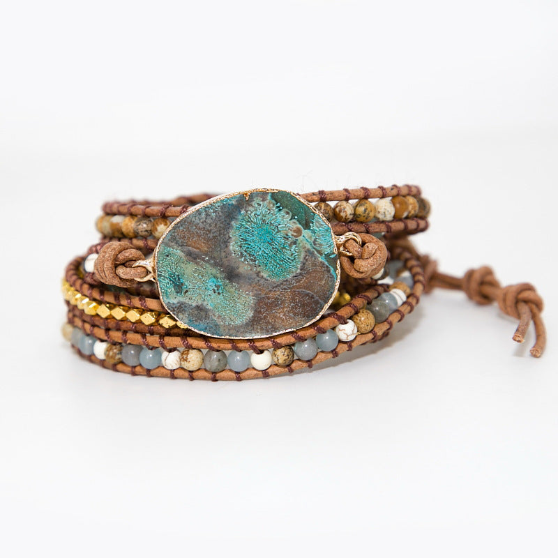 Multistrand bracelet with a large central stone on a white background