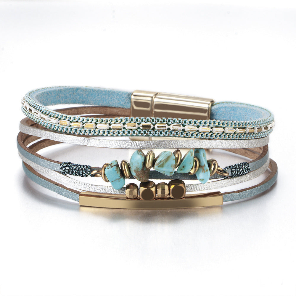 Stack of multistrand bracelets with turquoise stones and gold accents on a white background