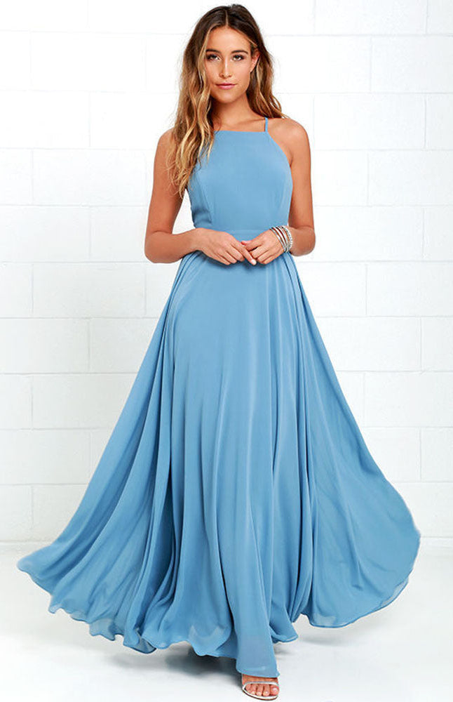 Woman wearing a long light blue dress against a white background