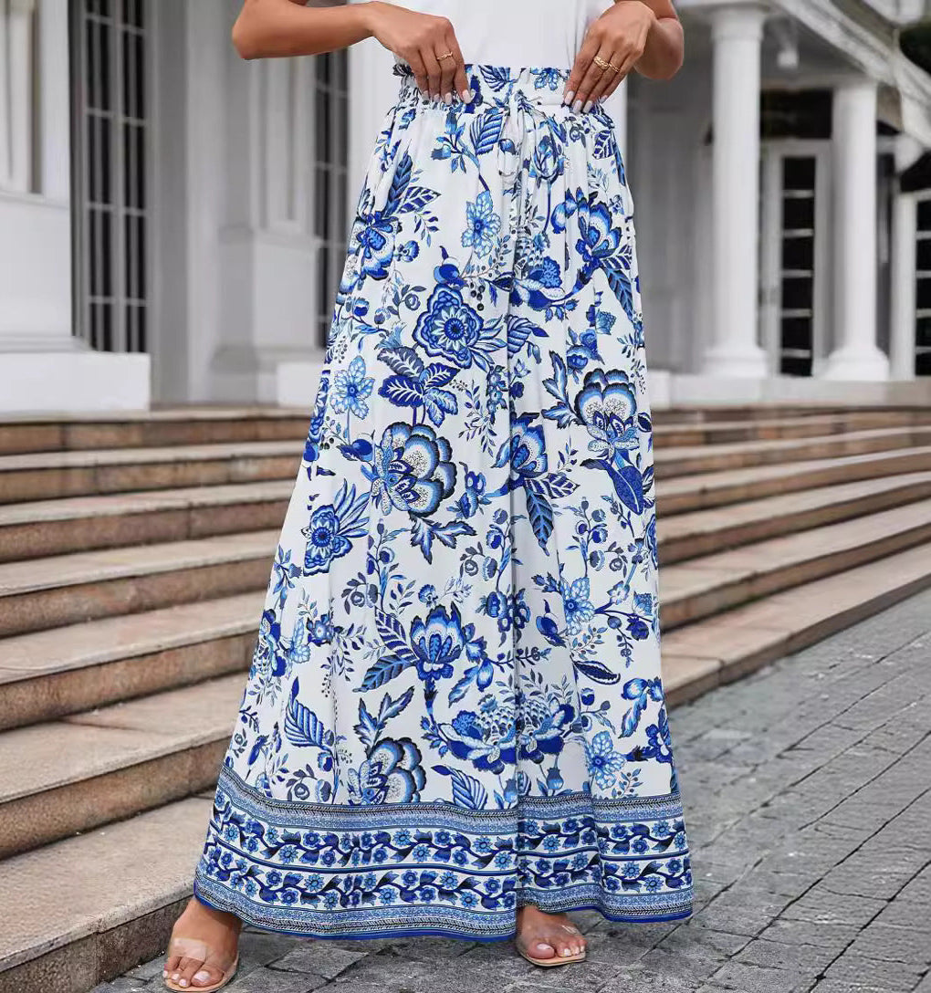 Person wearing a blue and white floral skirt standing on steps.