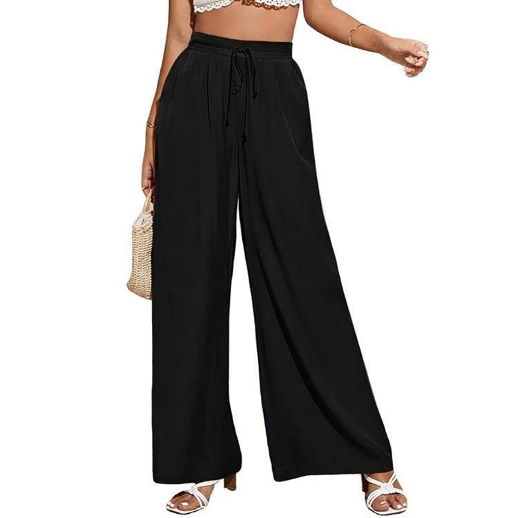 Black wide-leg pants worn by a person on a white background