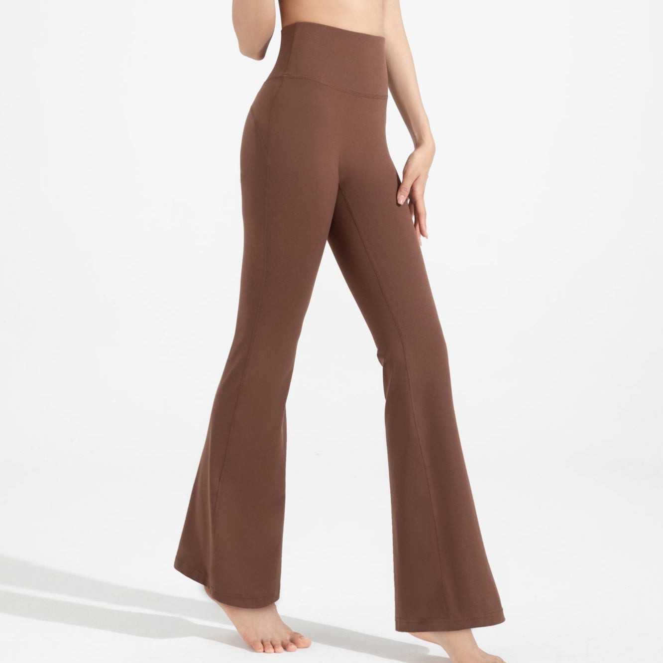 Brown flared pants worn by a person on a white background