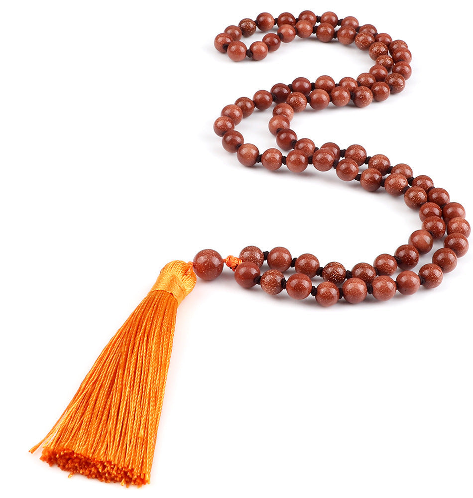 Brown beaded necklace with an orange tassel on a white background