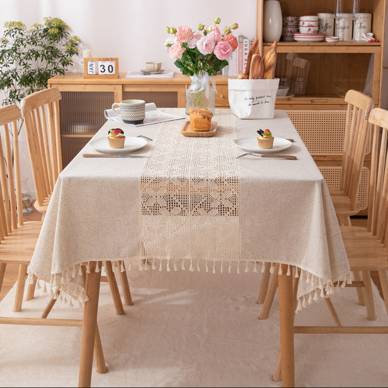 Dining room with a table set for a meal, featuring a lace tablecloth and decorative items.