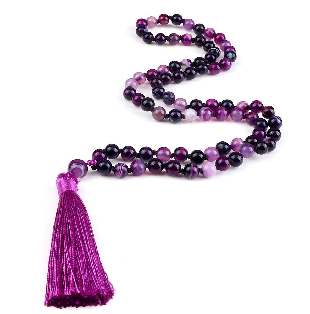 Purple beaded necklace with a tassel on a white background