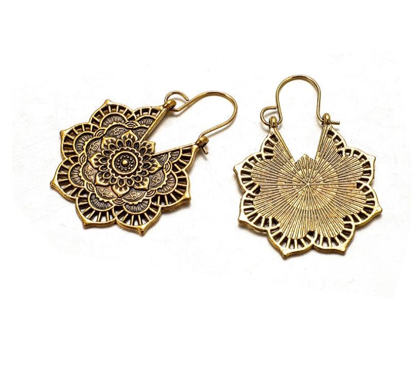 Pair of gold floral earrings on a white background