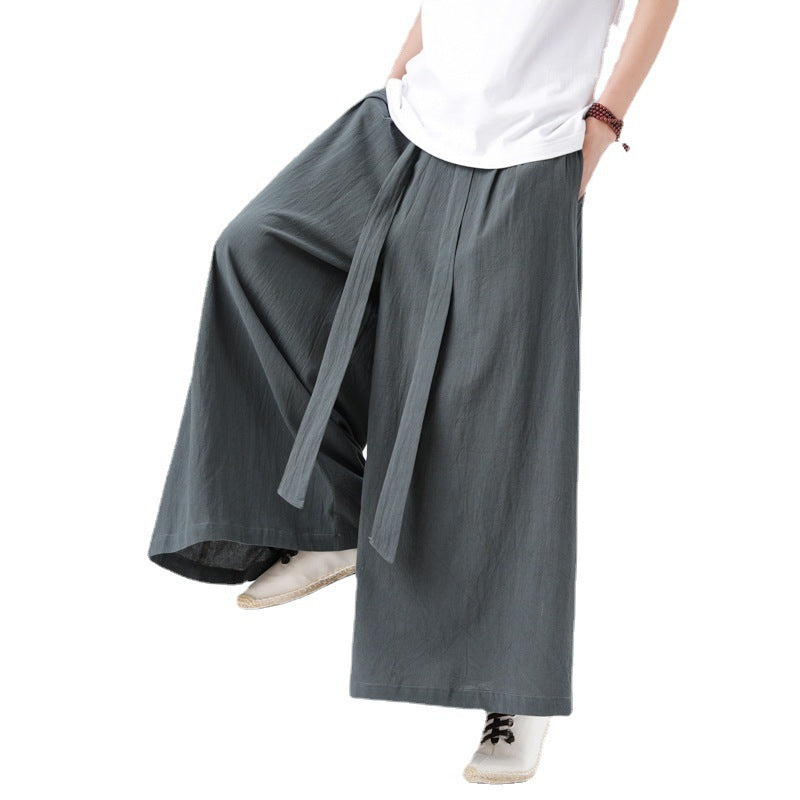Person wearing gray wide-leg pants and a white shirt on a white background