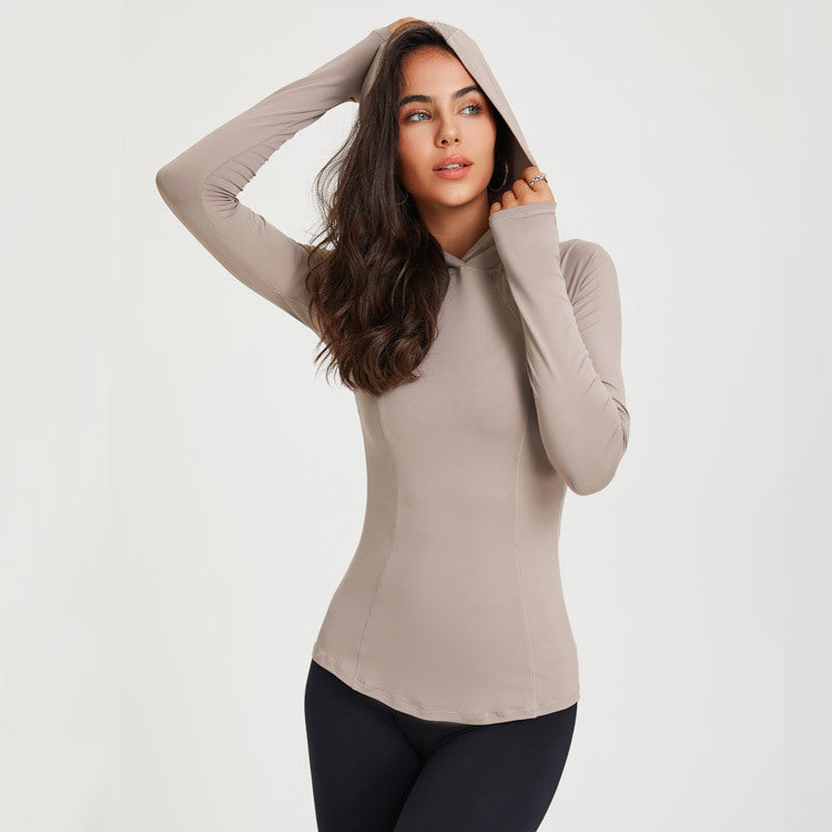 Woman wearing a beige long-sleeve top with a hood on a white background