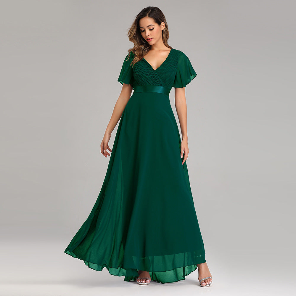 Woman wearing a green evening gown on a gray background