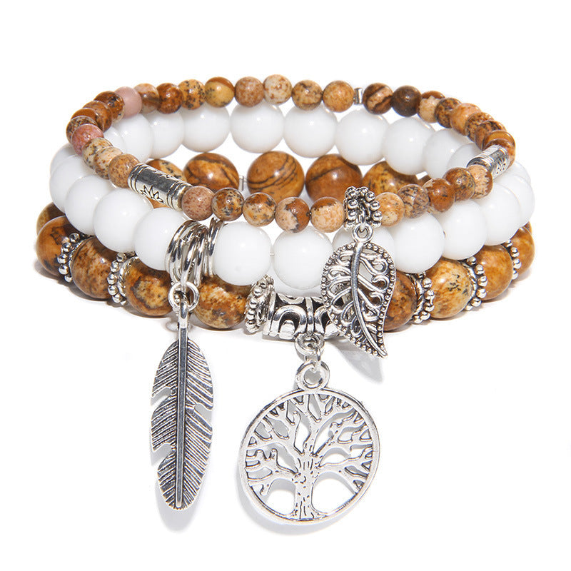 Stack of beaded bracelets with silver charms on a white background