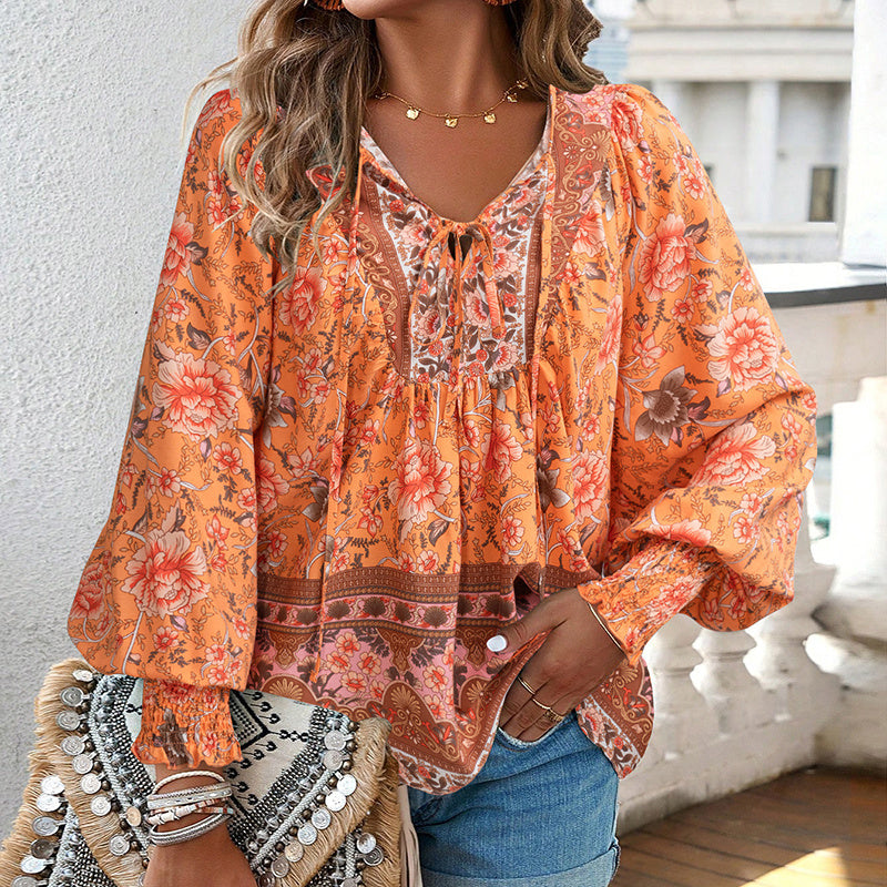 Woman wearing a floral orange blouse with a blurred background