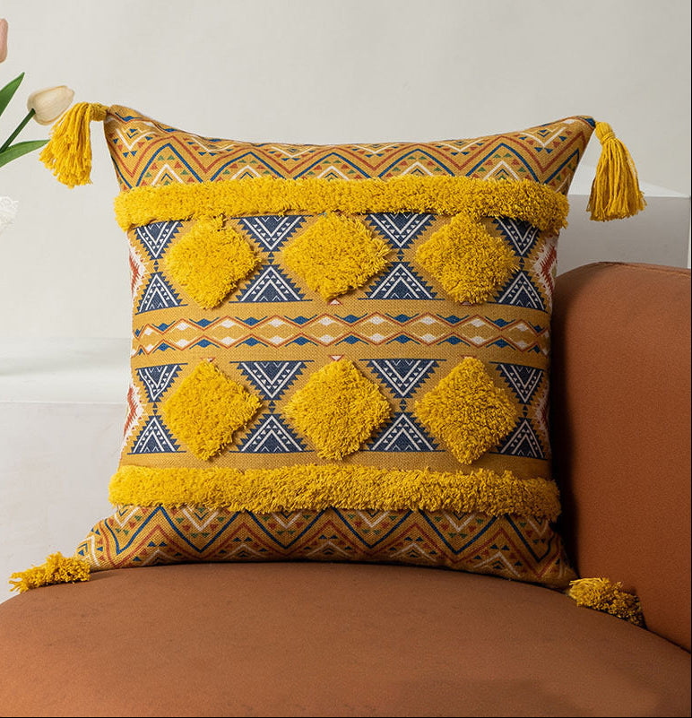 yellow Decorative pillow with chevron pattern and tassels on a brown couch