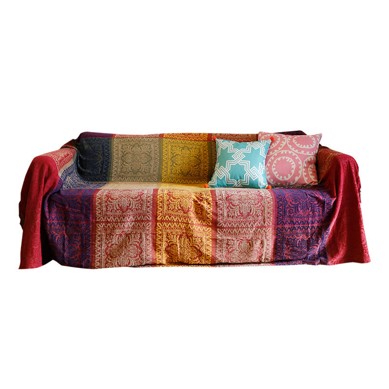 Multicolored patterned sofa with a blanket and cushions on a white background