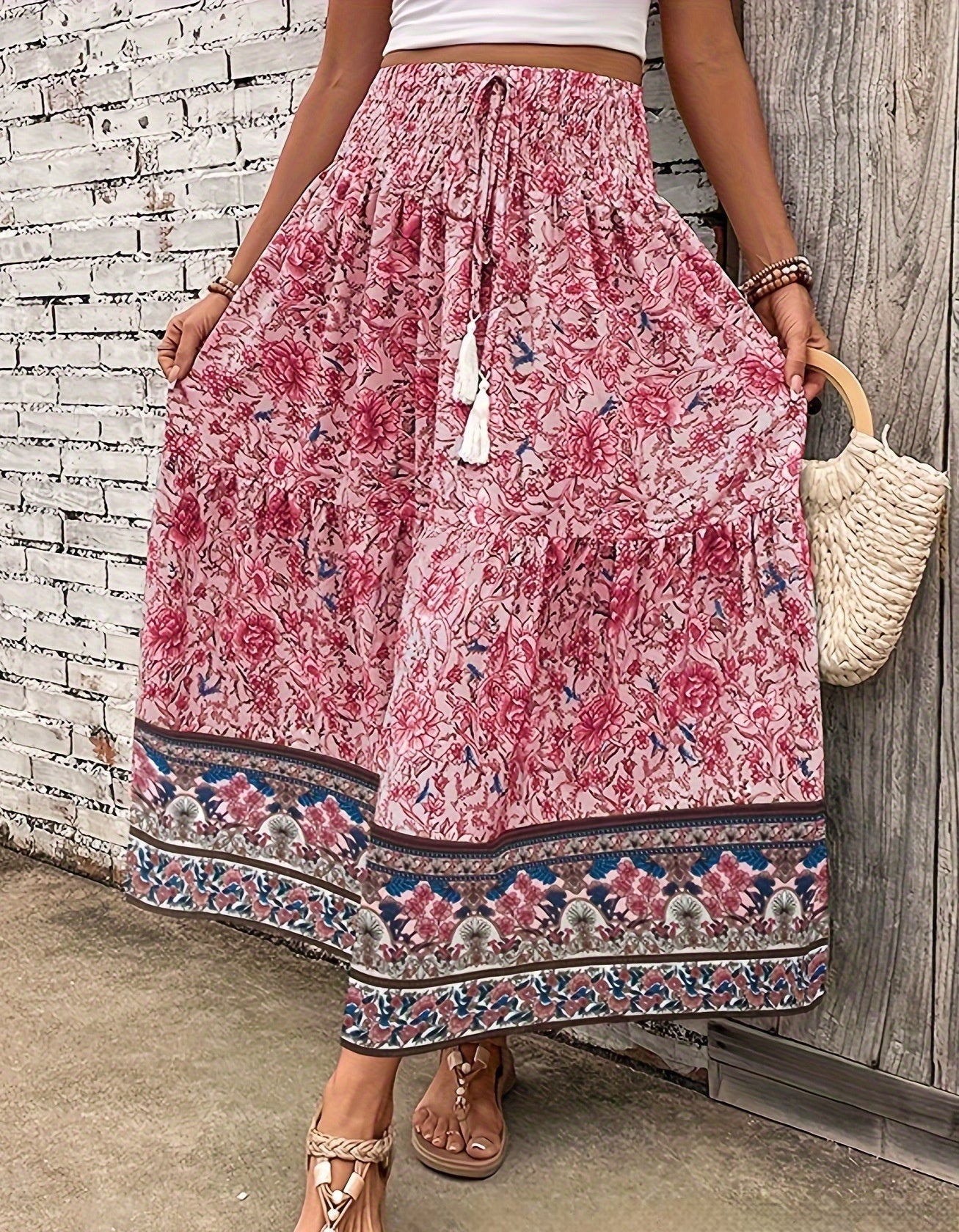 Person wearing a pink floral skirt with a wooden wall background