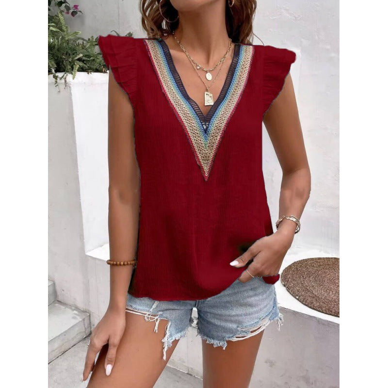Red sleeveless top with decorative neckline worn by a person outdoors.