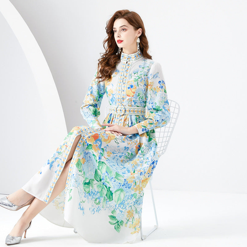 Woman wearing a floral dress sitting on a chair against a white background