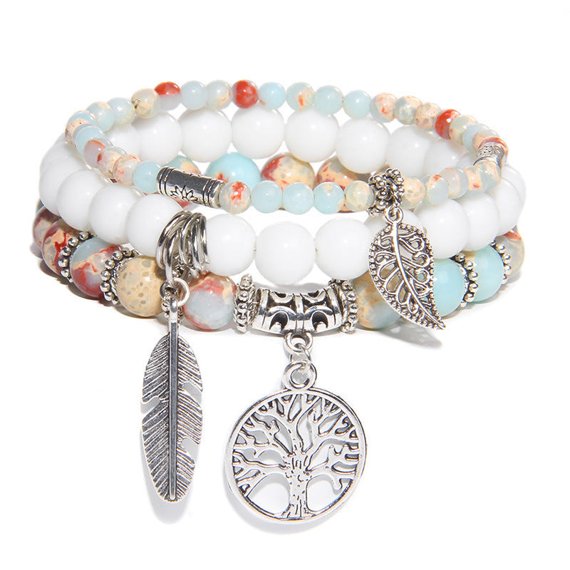 Multistrand beaded bracelet with silver charms on a white background