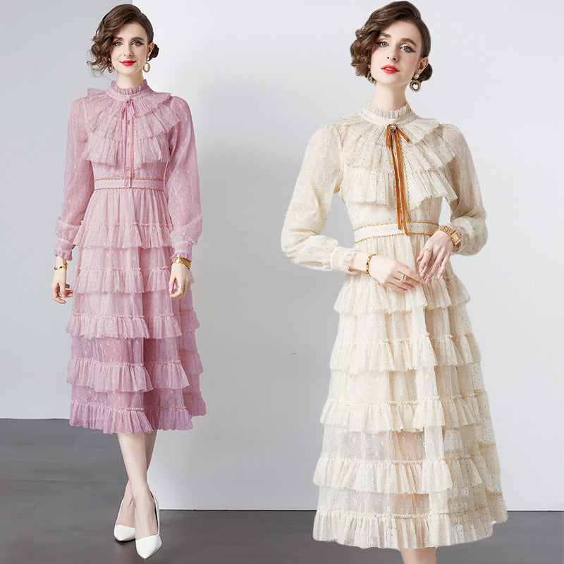 Two women wearing pink and beige ruffled dresses on a plain background