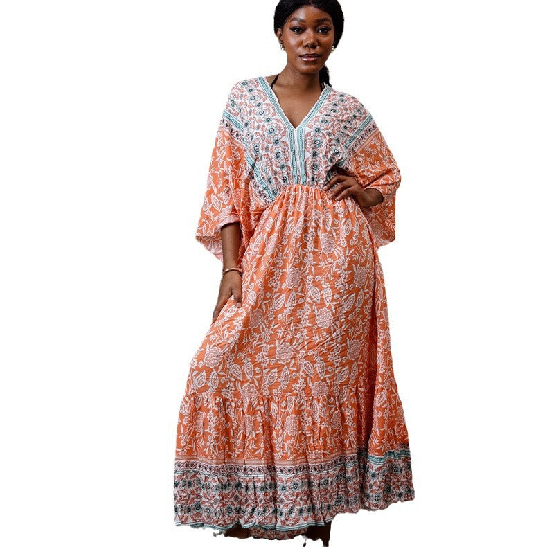 Woman wearing an orange and white patterned dress on a white background