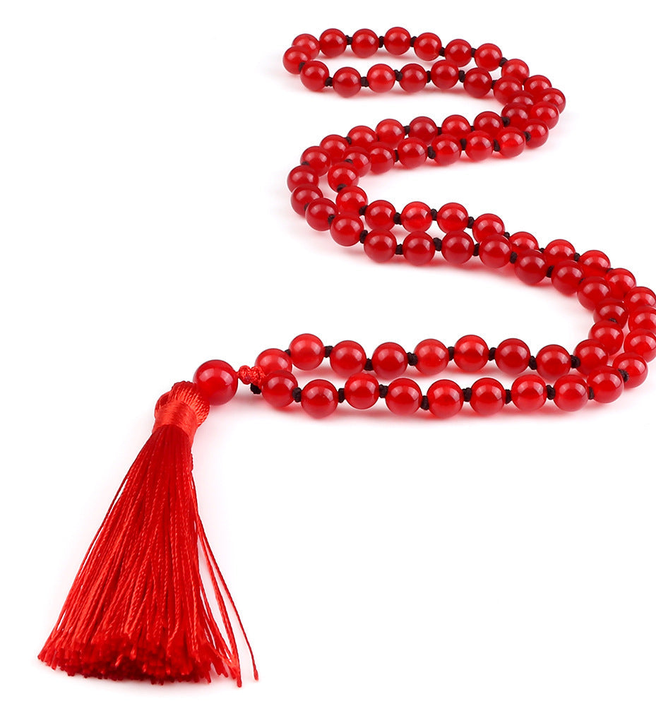 Red beaded necklace with a tassel on a white background