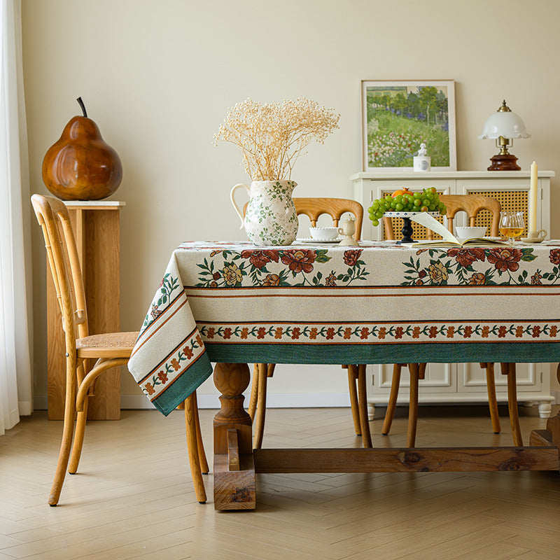 Dining room with wooden table and chairs, floral tablecloth, and decorative items.