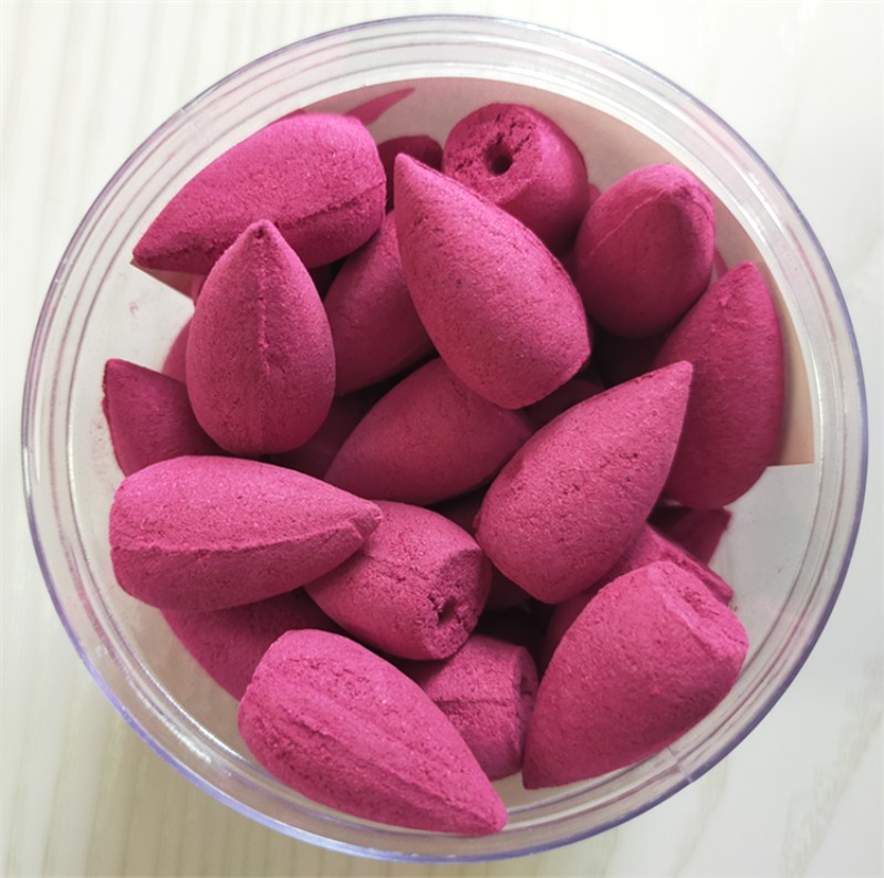 Pink incense cones in a clear container on a white background