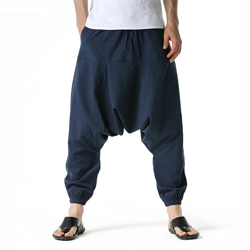 Navy harem pants worn by a person on a white background