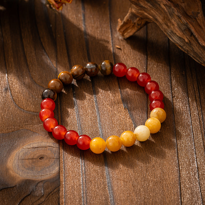 Beaded bracelet with red, yellow, and brown beads on a wooden surface
