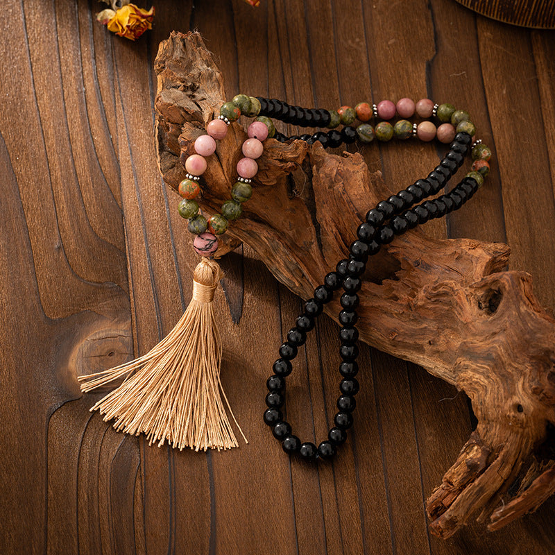 Beaded necklace with a tassel on a wooden surface