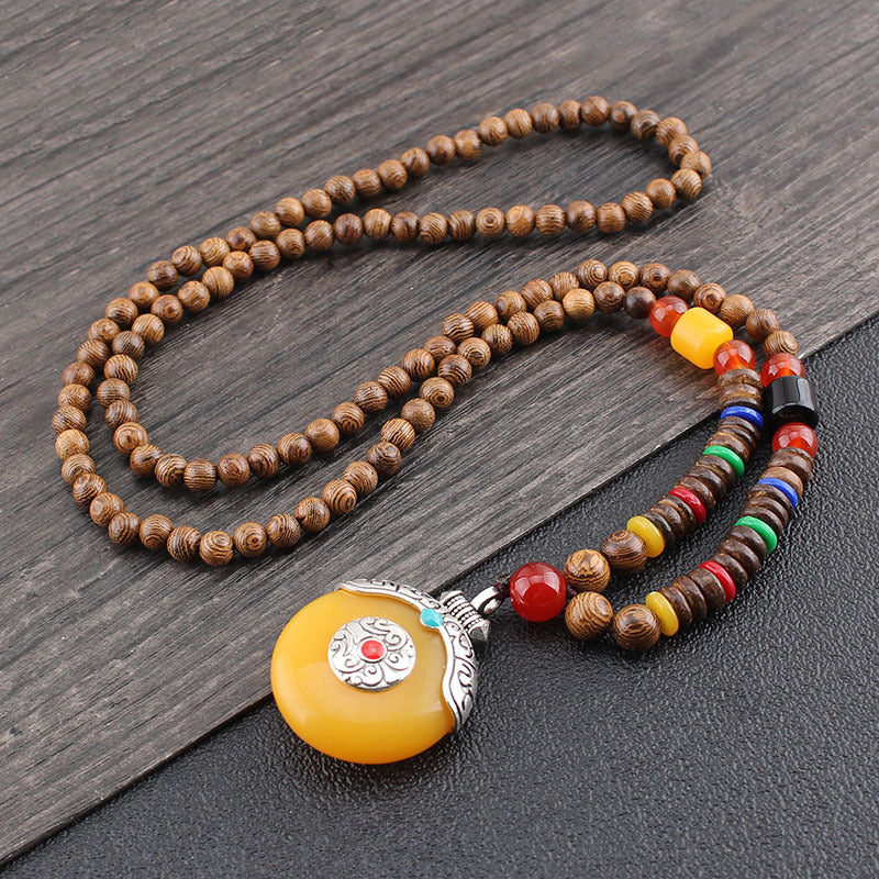 Beaded necklace with a yellow pendant on a wooden surface