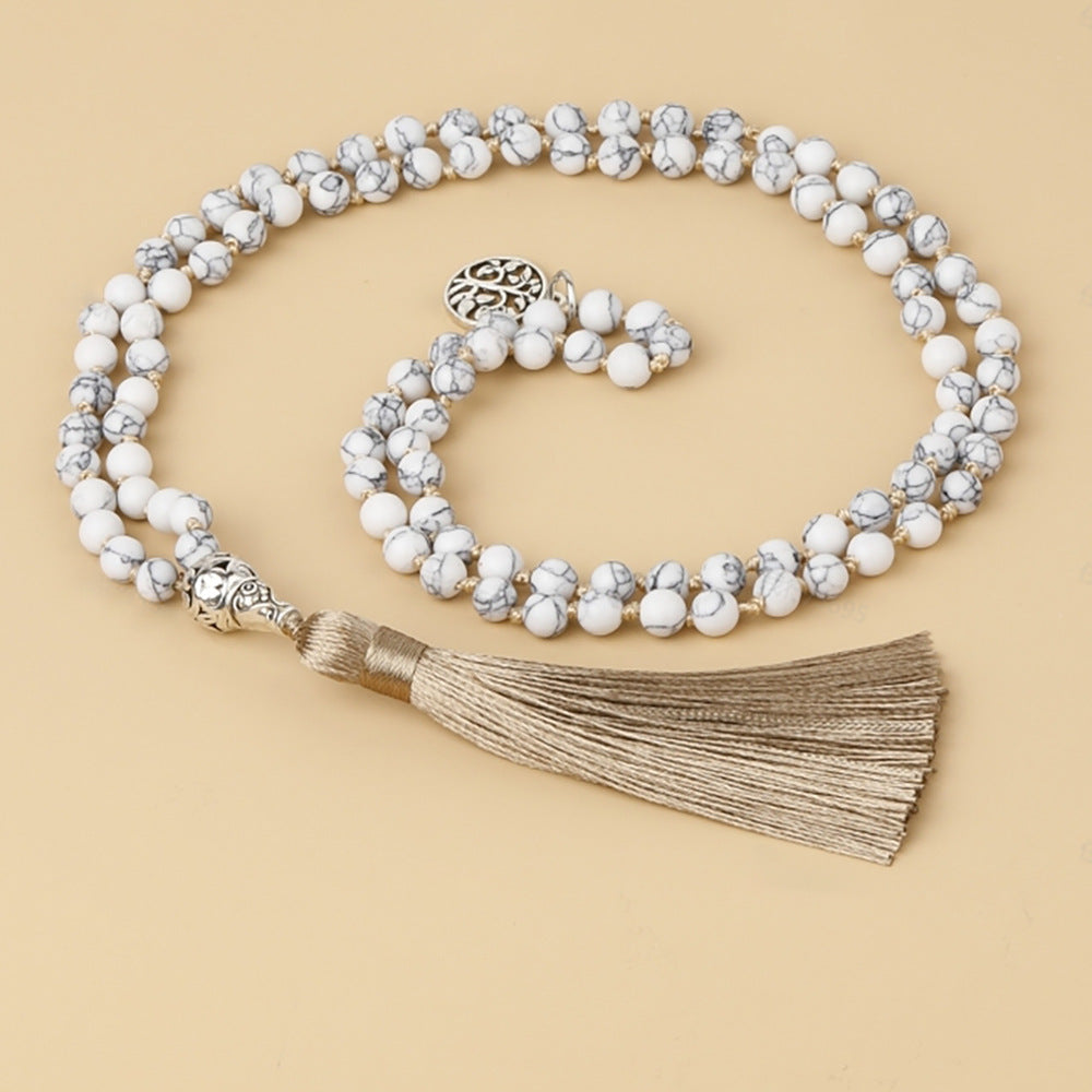 Beaded necklace with tassel on a beige background