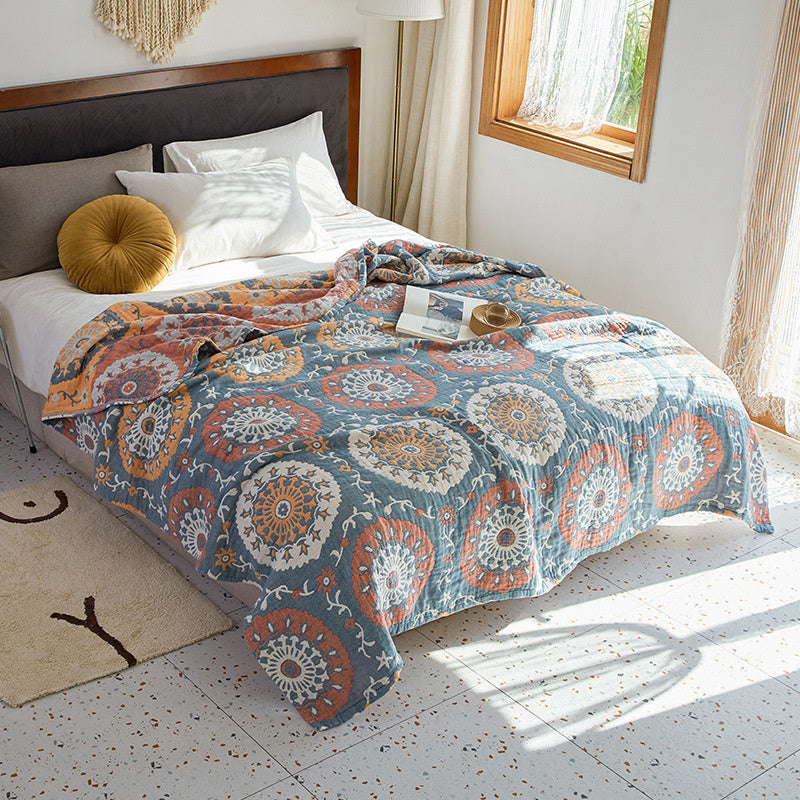 Bed with a patterned quilt in a bright bedroom