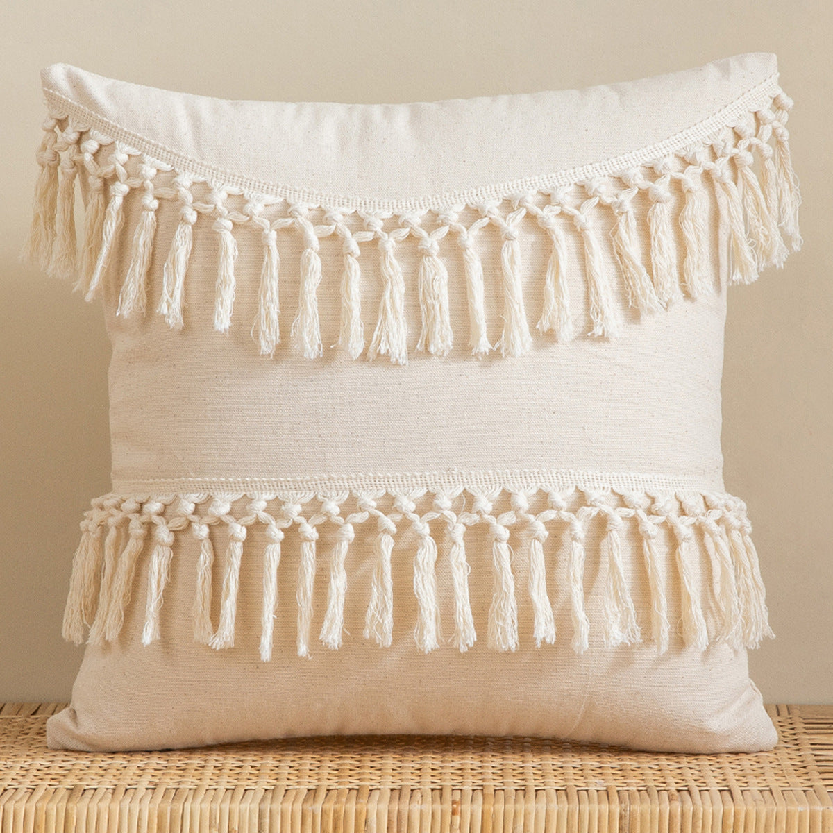 Beige pillow with tassels on a beige background