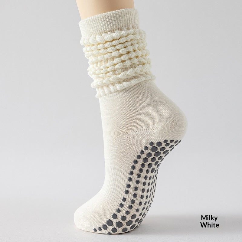 Beige ankle sock with textured pattern and black grip dots on a light gray background