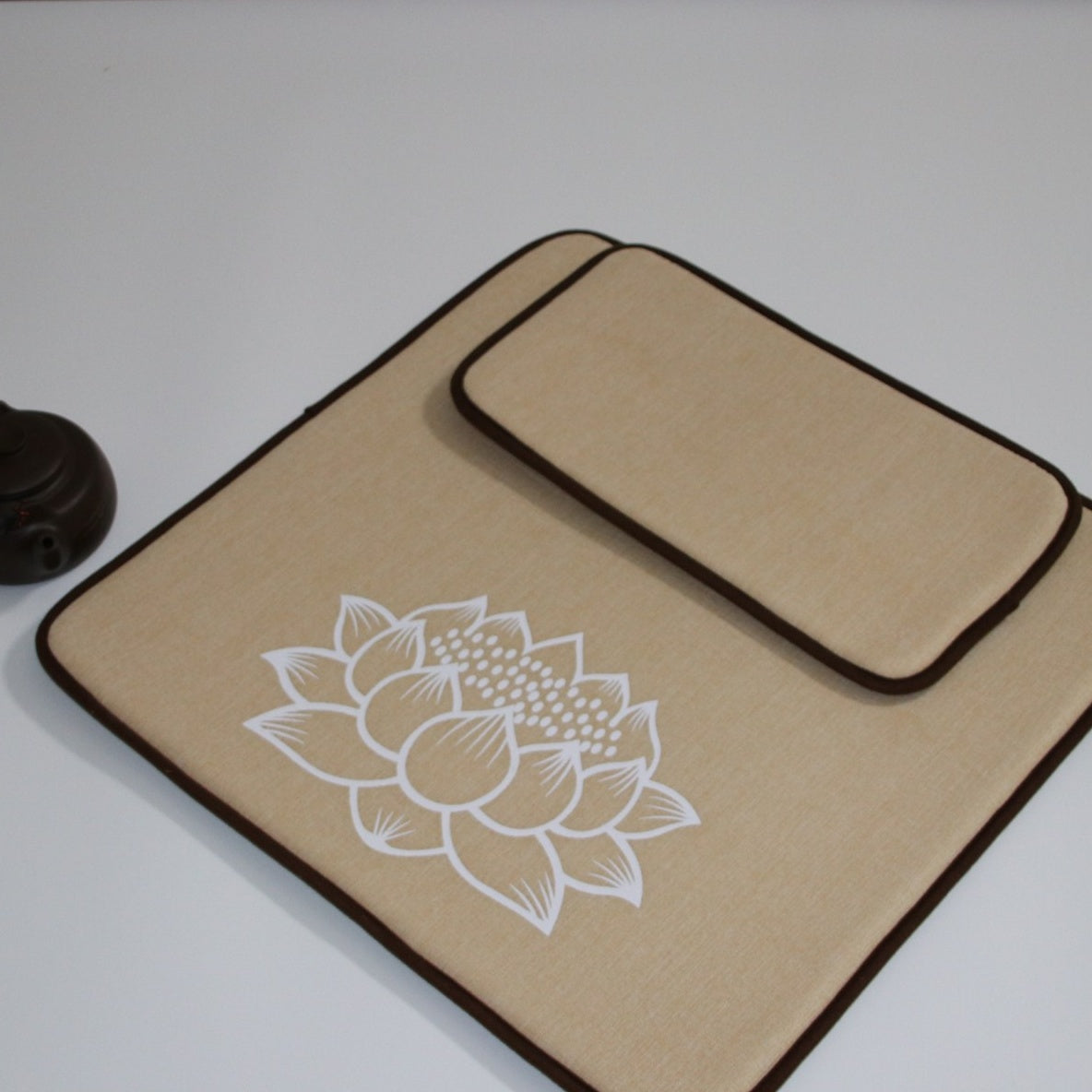Beige mat with white lotus design on a white background