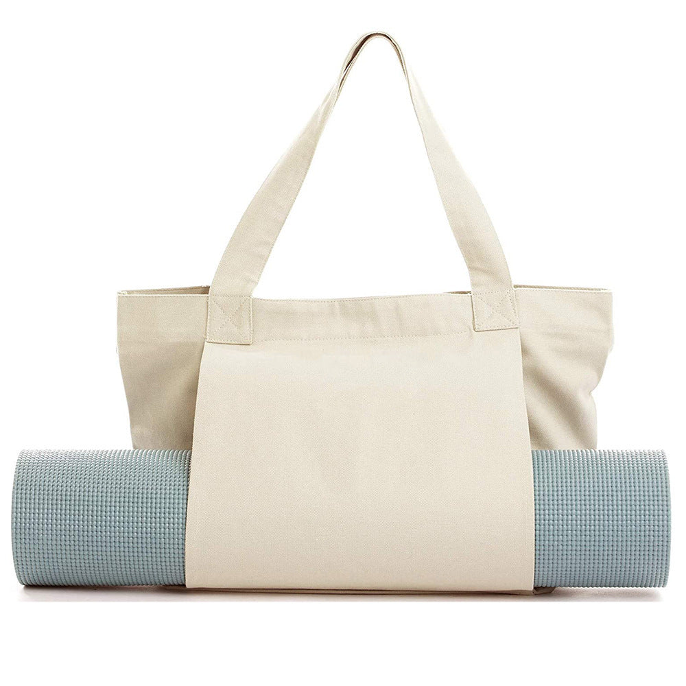 Beige tote bag with a blue yoga mat inside on a white background