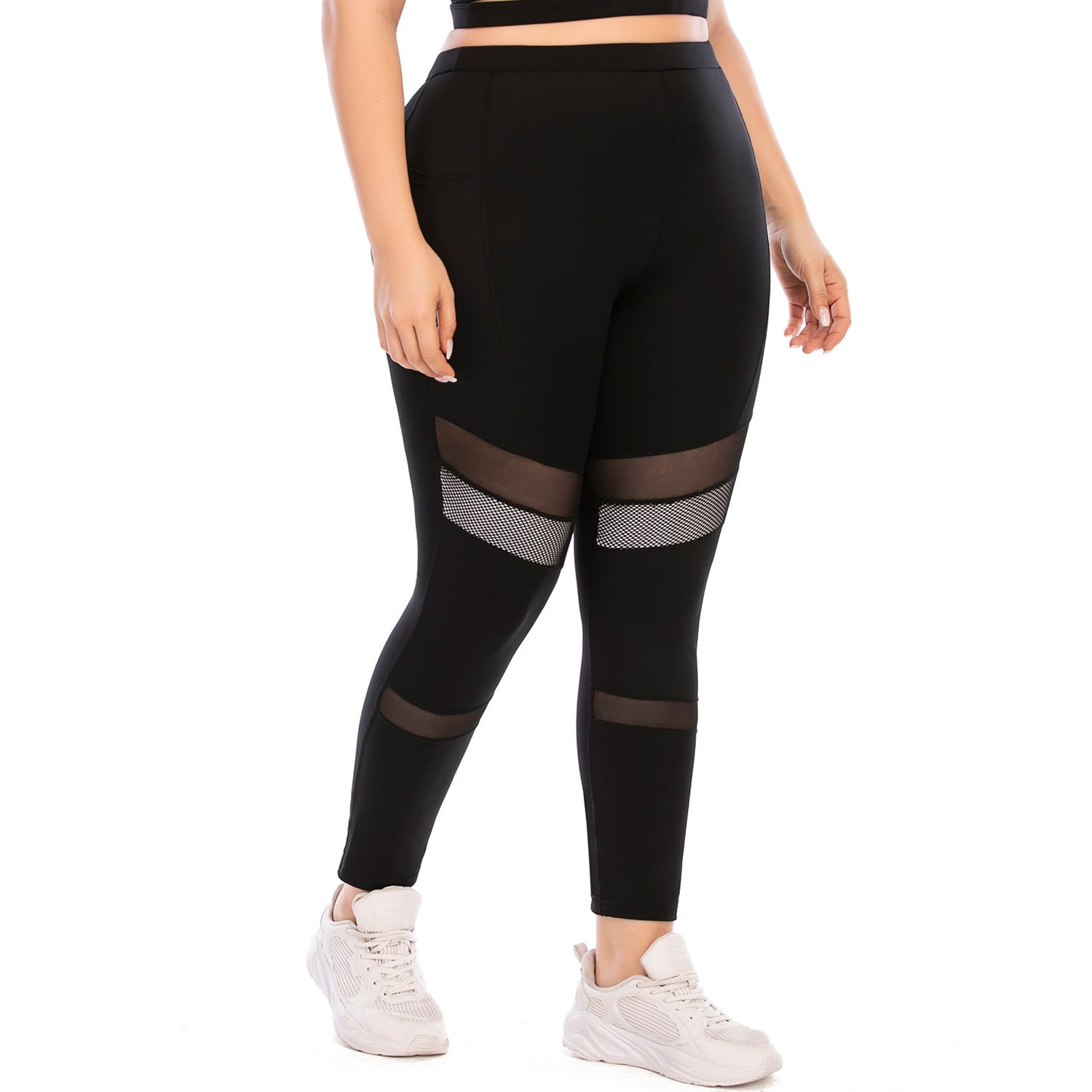 Black leggings with mesh panels worn by a person on a white background