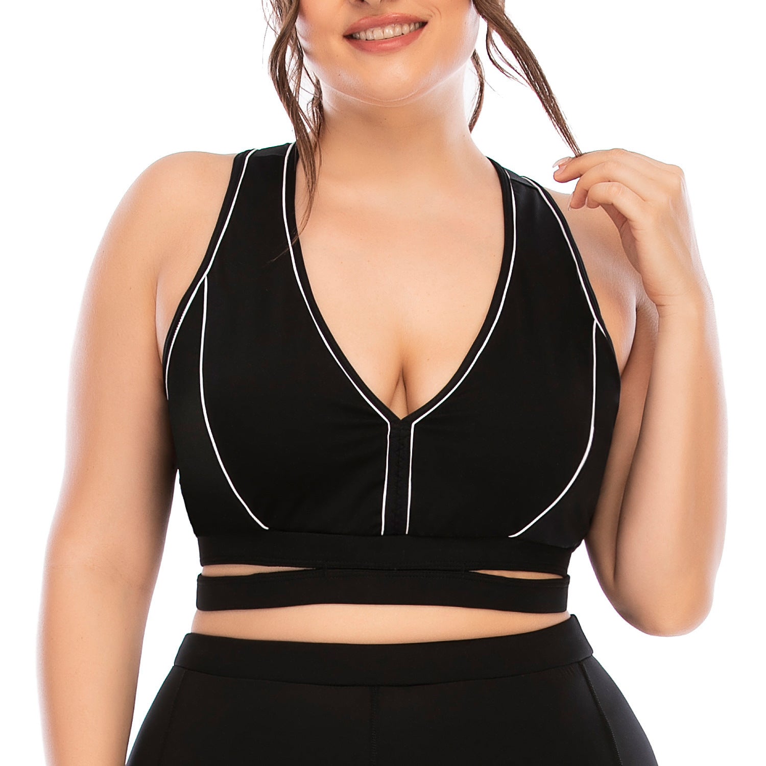 Black sports bra with white trim worn by a person on a white background