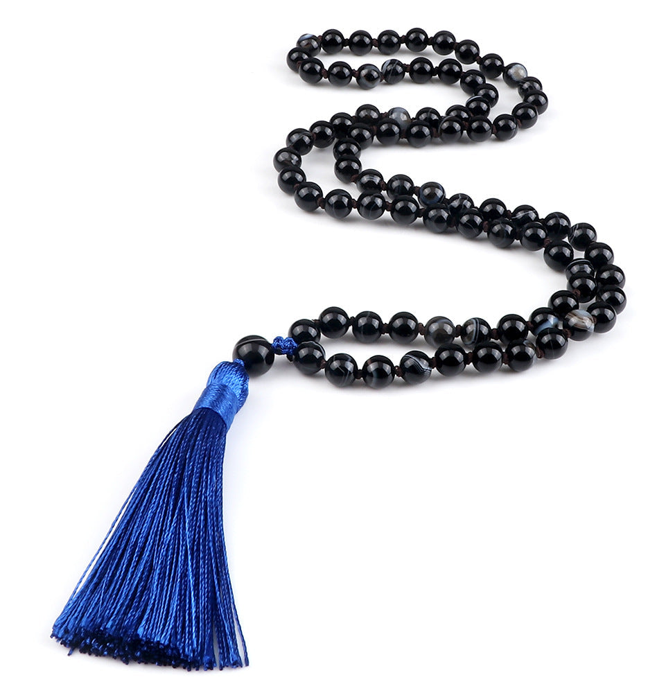 Black beaded necklace with a blue tassel on a white background