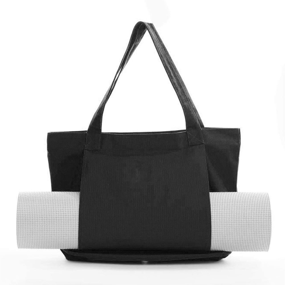 Black tote bag with a white yoga mat on a white background