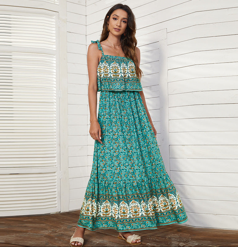 Woman wearing a teal floral dress with white patterns against a white wooden panel background