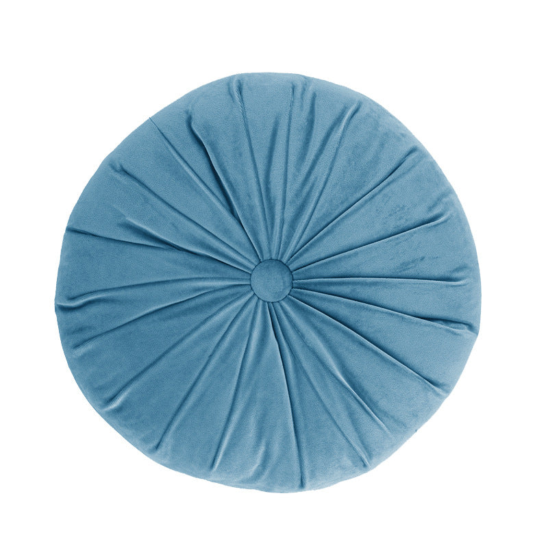 Blue round pillow with pleated texture on a white background