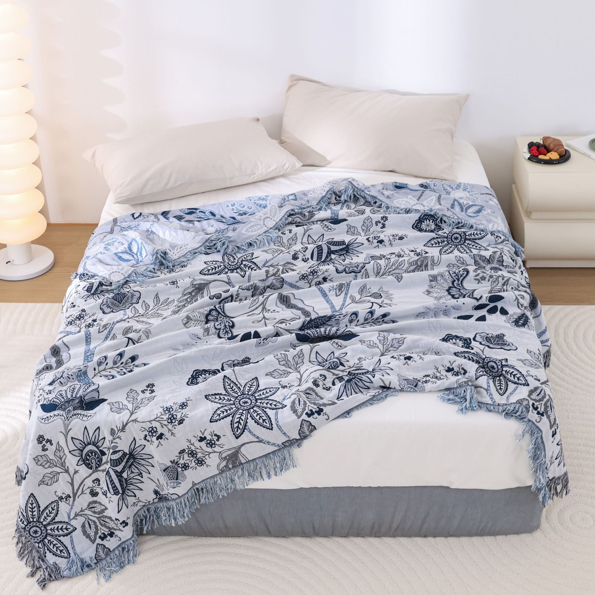 Floral patterned throw blanket on a bed in a bedroom setting